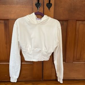 Cropped white sweatshirt with a hood and corset bottom